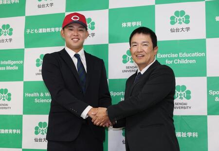 　広島から１位指名を受け森本吉謙監督（右）と握手する仙台大・平川蓮