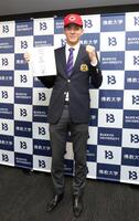 　広島５位に指名され、プロでの抱負の色紙を手にポーズを決める仏教大・赤木晴哉（撮影・山口登）