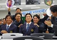 　広島から２位指名を受け、チームメートに祝福される亜大・斉藤汰直（中央）
