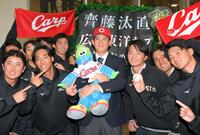 　広島に２位指名され、スラィリー人形を抱きしめる亜大・斉藤汰直（中央）＝撮影・伊藤笙子