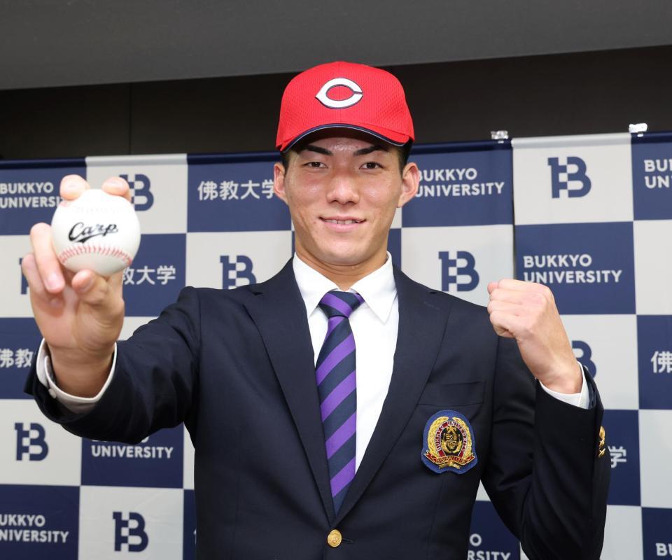 　広島５位に指名されポーズを決める仏教大・赤木晴哉（撮影・山口登）