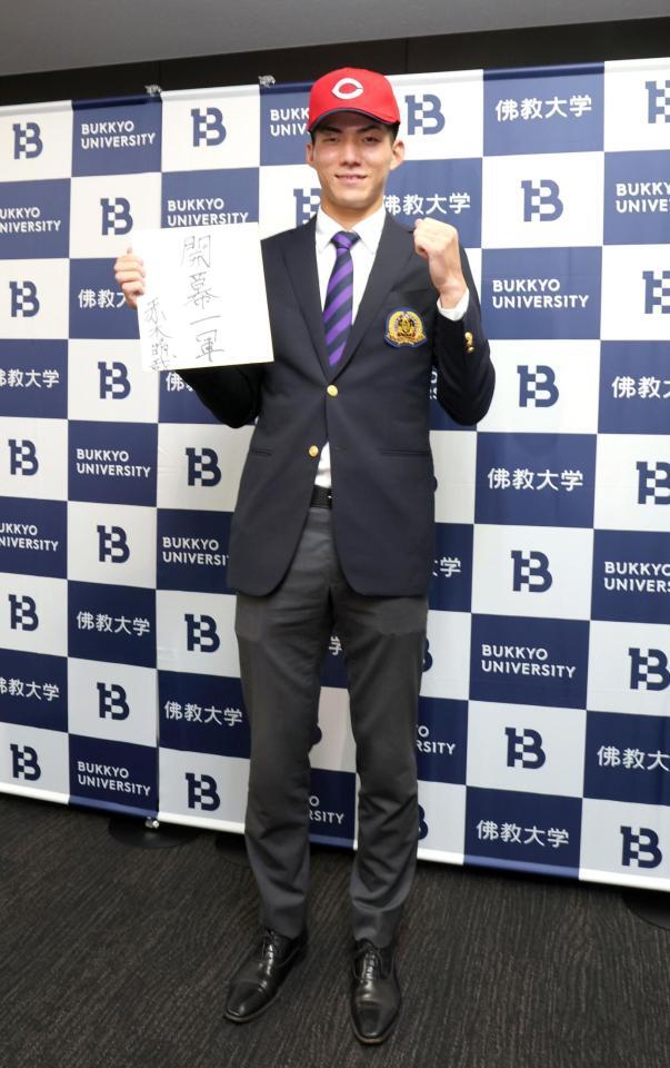 　広島５位に指名され、プロでの抱負の色紙を手にポーズを決める仏教大・赤木晴哉（撮影・山口登）