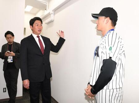 　仙台から東京に移動し亜大・斉藤汰直（右）と話す新井監督（撮影・佐藤厚）