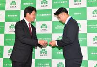 　新井監督（左）からドラフト会議で引いた当たりクジをプレゼントされ感激の１位指名の仙台大・平川蓮（撮影・開出牧）