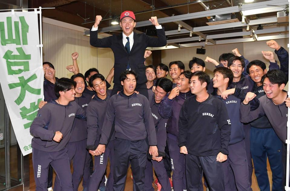 　広島に１位指名され野球部員に祝福される仙台大・平川（撮影・開出牧）