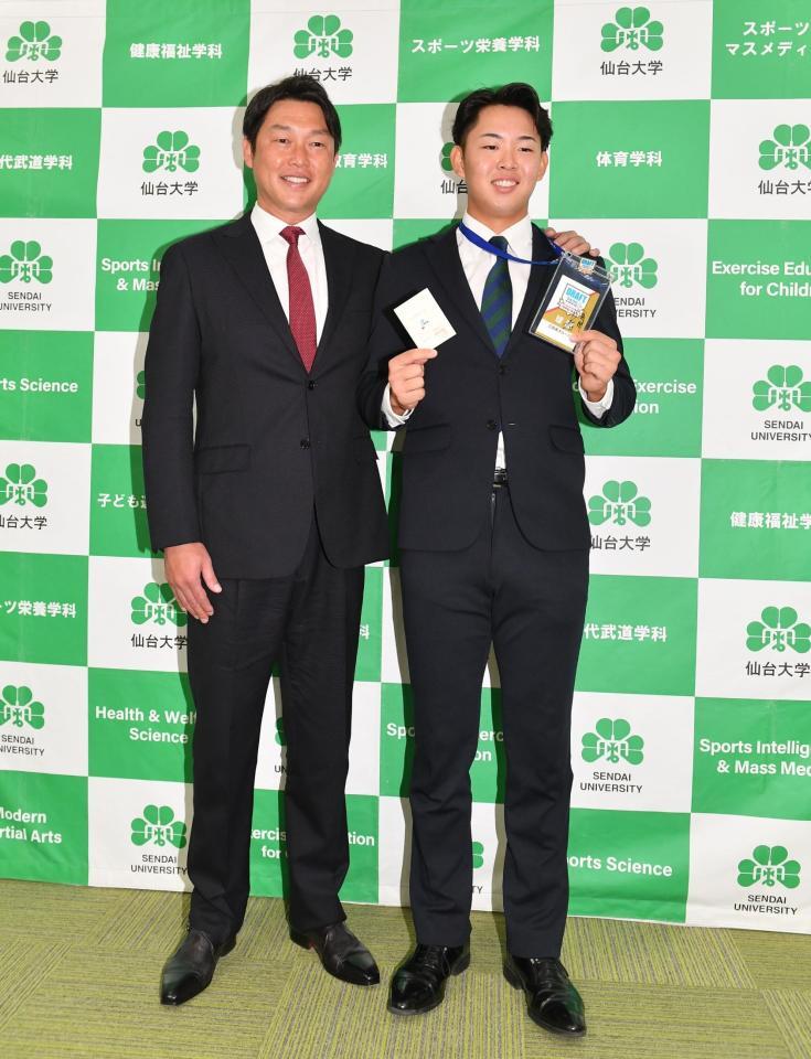 　新井監督（左）からドラフト会議で引いた当たりクジをプレゼントされ感激の１位指名の仙台大・平川蓮（撮影・開出牧）