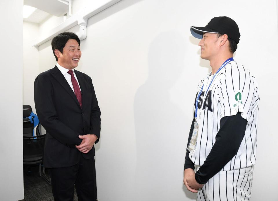 　仙台から東京に移動し亜大・斉藤汰直（右）と話す新井監督（撮影・佐藤厚）