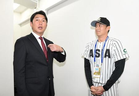 　仙台から東京に移動し亜大・斉藤汰直（右）と話す新井監督（撮影・佐藤厚）