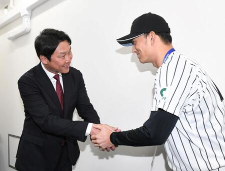 　亜大・斉藤汰直（右）と笑顔で握手する新井監督（撮影・佐藤厚）