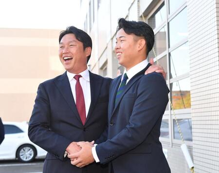 　指名あいさつに訪れた新井監督（左）を出迎え握手を交わす仙台大・平川蓮（撮影・開出牧）