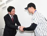 　亜大・斉藤汰直（右）と笑顔で握手する新井監督（撮影・佐藤厚）
