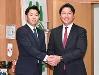 　指名あいさつに訪れた新井監督（右）と握手をかわす１位指名の仙台大・平川蓮（撮影・開出牧）