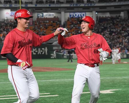 　笑顔でタッチを交わす磯村（右）と堂林