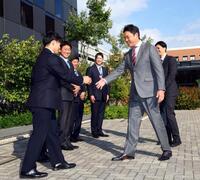 　近大・勝田成（左）のドラフトの指名あいさつに訪れた新井監督は笑顔で握手をかわす（撮影・山口登）