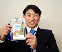 　近大・勝田成は新井監督のサインをされたドラフト会議のパスを手に笑顔を見せる（撮影・山口登）