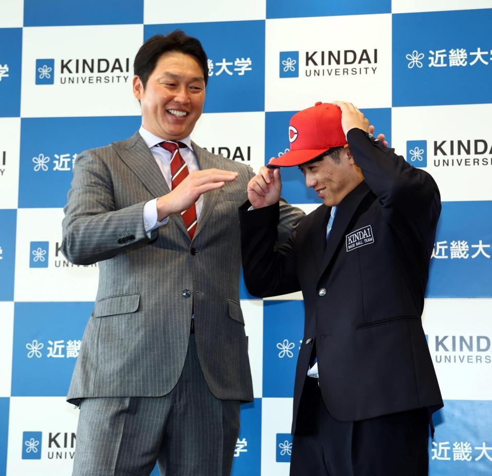 　新井監督（左）から帽子を被せてもらう近大・勝田成（撮影・山口登）