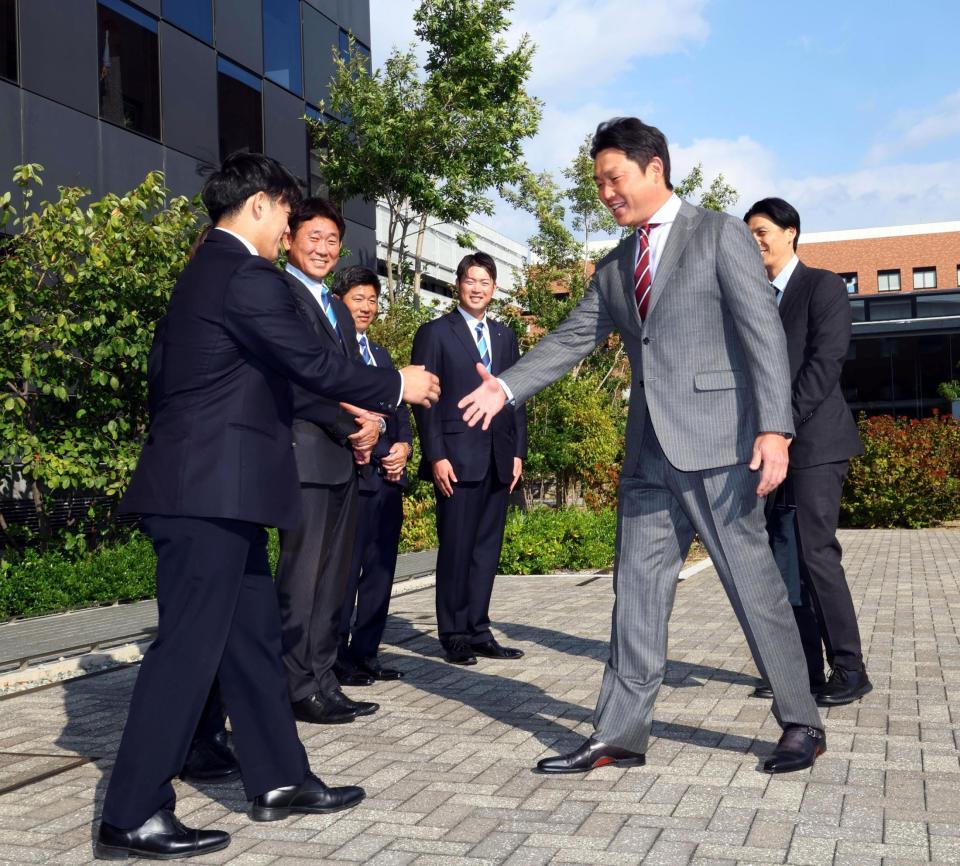 　近大・勝田成（左）のドラフトの指名あいさつに訪れた新井監督は笑顔で握手をかわす（撮影・山口登）