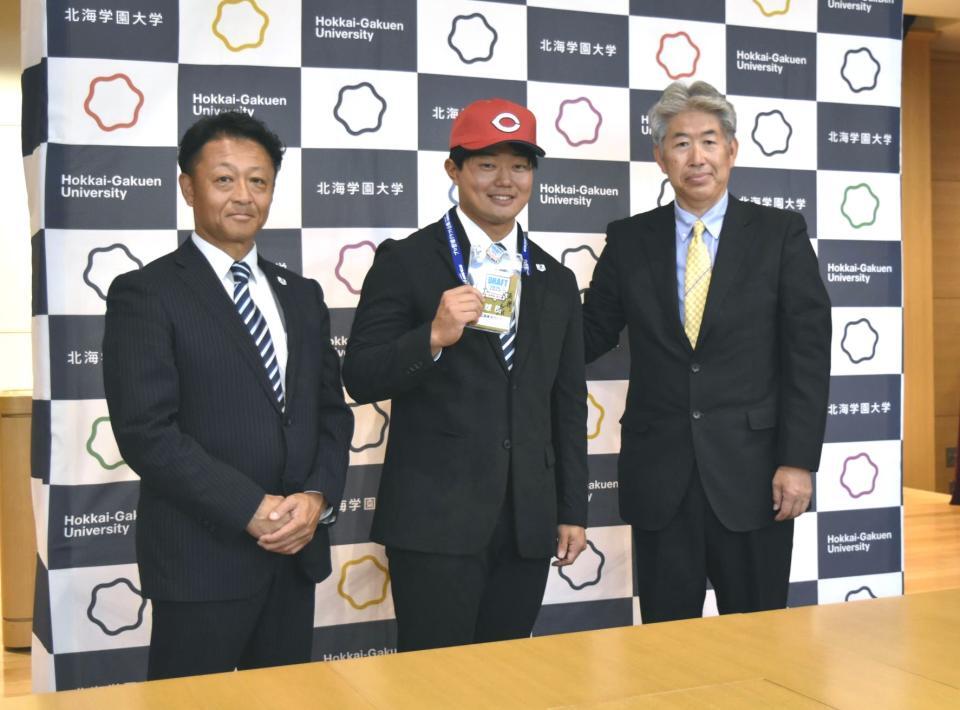 　笑顔を見せる北海学園大・工藤（中央）左は同大の島崎監督、右は担当の近藤スカウト