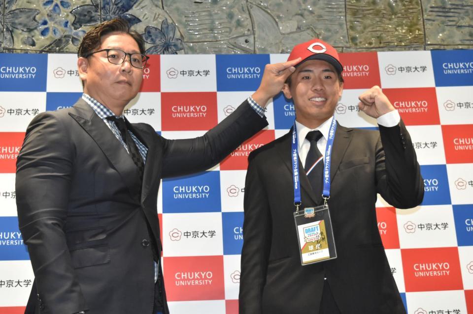 　松本スカウト（左）から帽子をかぶせてもらい、笑顔の中京大・高木（右）