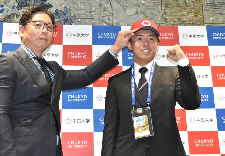 　松本スカウト（左）から帽子をかぶせてもらい、笑顔の中京大・高木