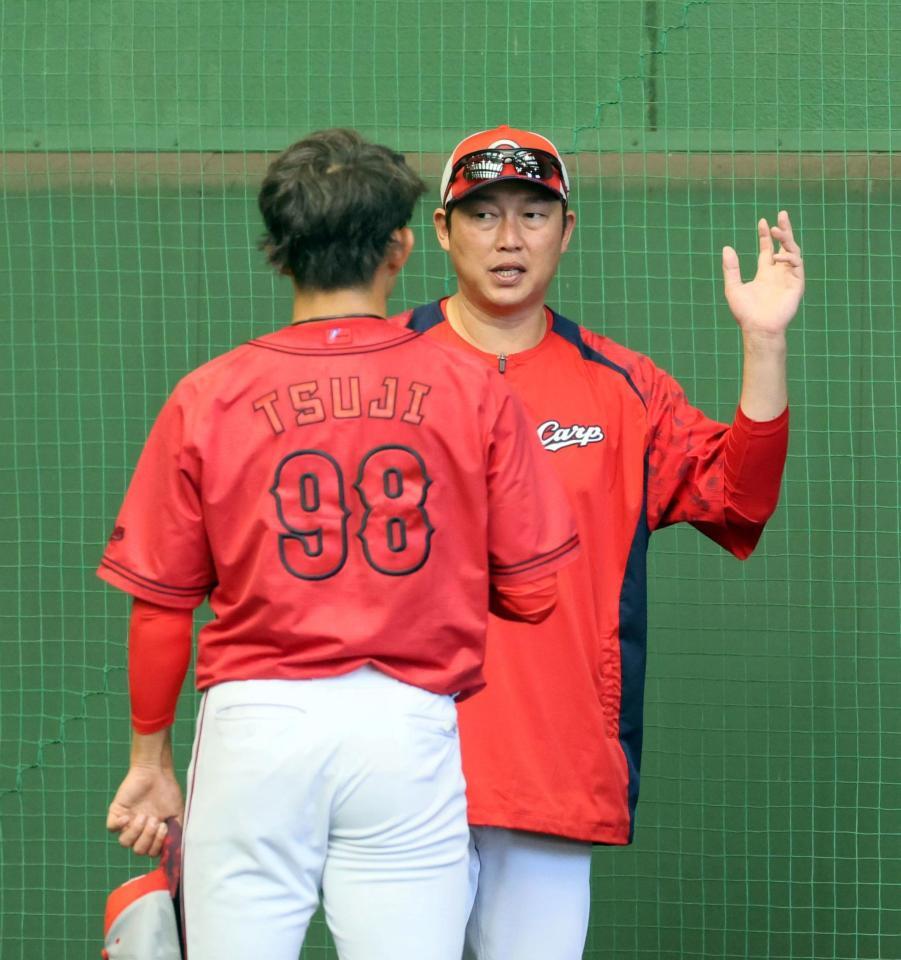 　ブルペンで辻と話をする新井監督（撮影・市尻達拡）