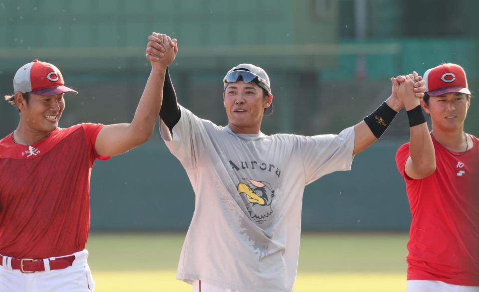 　全体練習終了後、渡辺（左）と佐々木（右）の手を持ち上げる久保（撮影・市尻達拡）