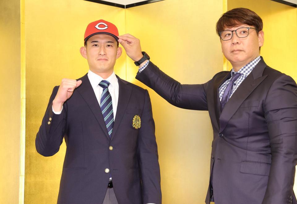 　松本有史スカウト（右）から帽子をかぶせてもらうドラフト２位指名の斉藤汰直（撮影・西岡正）