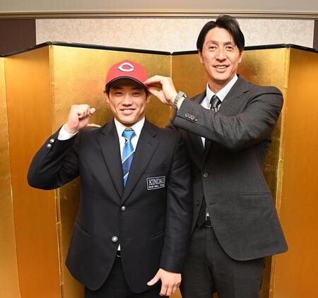 　仮契約を終え、鞘師スカウト（右）から帽子をかぶせてもらう近大・勝田成（撮影・西田忠信）