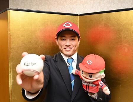 　仮契約を終え笑顔でポーズを決める近大・勝田成（撮影・西田忠信）