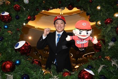 　仮契約を終え、広島グッズを手にポーズを決める近大・勝田成（撮影・西田忠信）