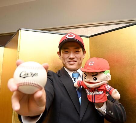 　仮契約を終え、広島グッズを手に笑顔の近大・勝田成（撮影・西田忠信）