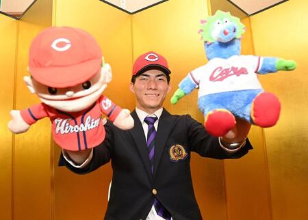 　仮契約を終え、広島グッズを手に笑顔の仏教大・赤木晴哉（撮影・西田忠信）