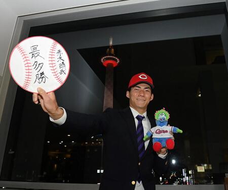 　プロでの目標を書いた色紙を手にポーズをとる仏教大・赤木晴哉（撮影・西田忠信）