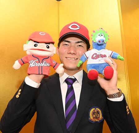 　仮契約を終え、広島グッズを手に笑顔の仏教大・赤木晴哉（撮影・西田忠信）