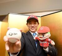 　仮契約を終え、広島グッズを手に笑顔の近大・勝田成（撮影・西田忠信）