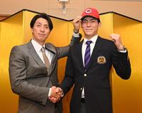 　仮契約を終え、鞘師智也スカウト（左）に帽子をかぶせてもらう仏教大・赤木晴哉（撮影・西田忠信）