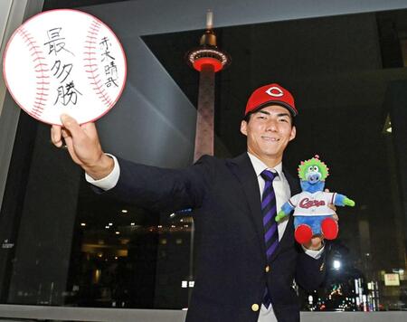 　プロでの目標を書いた色紙を手にポーズをとるドラフト５位赤木（撮影・西田忠信）