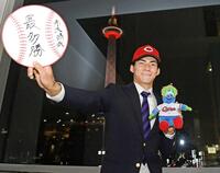 　プロでの目標を書いた色紙を手にポーズをとるドラフト５位赤木（撮影・西田忠信）