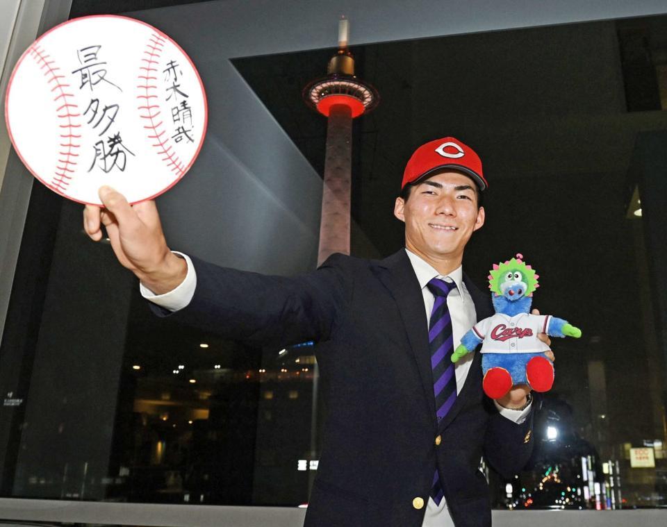 　プロでの目標を書いた色紙を手にポーズをとるドラフト５位赤木（撮影・西田忠信）