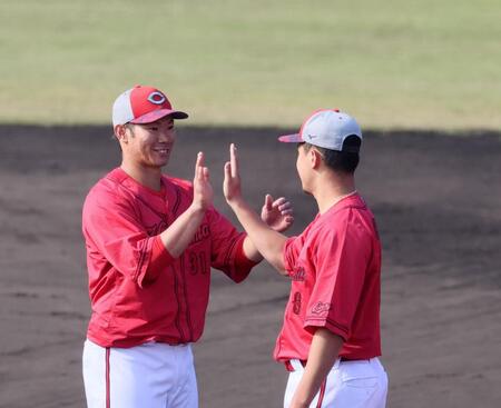 　秋季キャンプを終え、森（右）とタッチを交わす坂倉（撮影・市尻達拡）