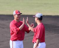 　秋季キャンプを終え、森（右）とタッチを交わす坂倉（撮影・市尻達拡）