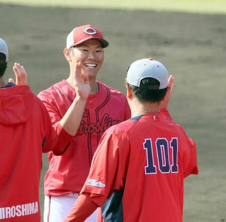 　秋季キャンプを打ち上げ、笑顔でタッチを交わす坂倉（撮影・市尻達拡）