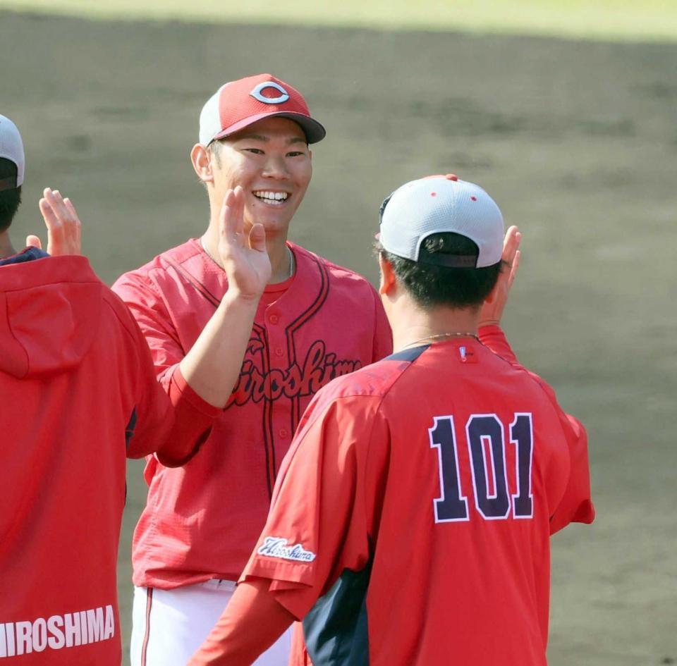 　秋季キャンプを打ち上げ、笑顔でタッチを交わす坂倉（撮影・市尻達拡）