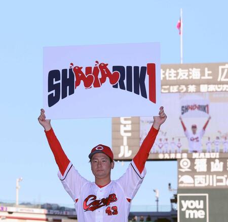 　来季のキャッチフレーズ「ＳＨＡＫＡＲＩＫＩ」のボードを掲げる島内（撮影・市尻達拡）