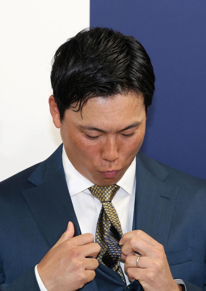 　裏表両方を使用できるネクタイを見せる栗林（撮影・市尻達拡）