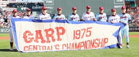 　７５年初優勝メンバーの（左から）ゲイル・ホプキンス氏、外木場義郎氏、山本浩二氏、渡辺弘基氏、道原裕幸氏、木下富雄氏、佐伯和司氏、池谷公二郎氏、金城基泰氏がペナントを持って撮影に応じる（撮影・市尻達拡）