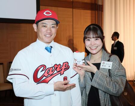 　背番号「０」が入ったハローキティの人形を手にする姉・舞さんとの記念撮影に応じるドラフト３位の勝田成（撮影・市尻達拡）