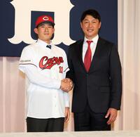 　新井監督（右）と握手をするドラフト２位の斉藤汰直（撮影・市尻達拡）