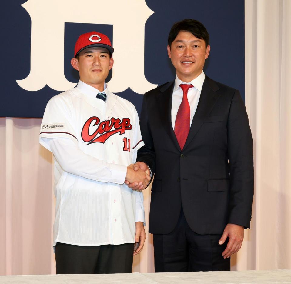 　新井監督（右）と握手をするドラフト２位の斉藤汰直（撮影・市尻達拡）