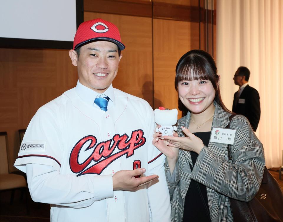 　背番号「０」が入ったハローキティの人形を手にする姉・舞さんとの記念撮影に応じるドラフト３位の勝田成（撮影・市尻達拡）